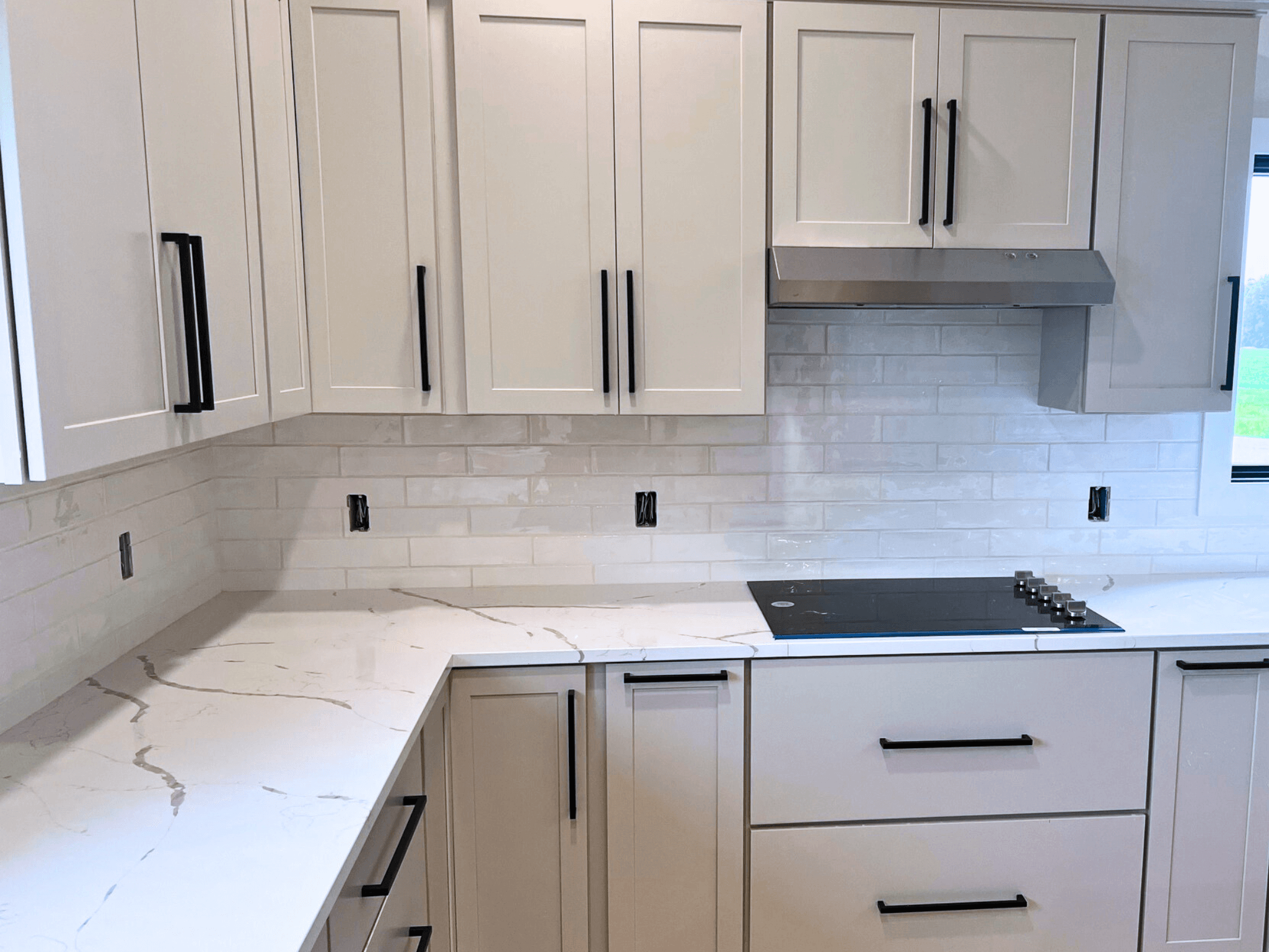 A kitchen with white tile backdrop. 